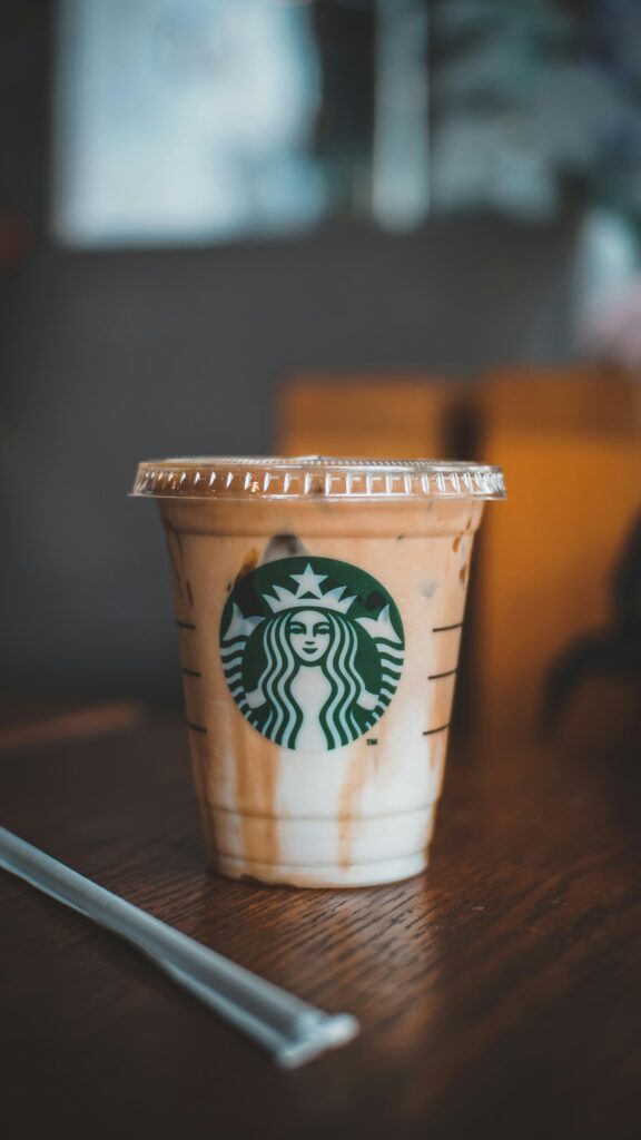 Starbucks coffee cup with Pumpkin Spice Crème branding on a green background
